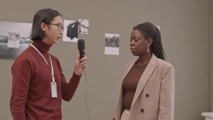 画廊主接受非裔美国女摄影师的采访