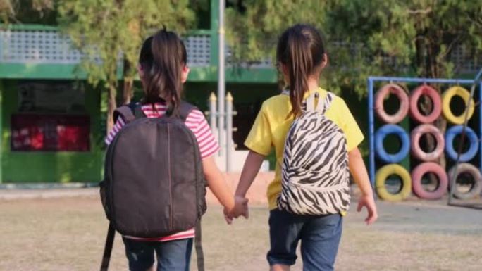 两个可爱的女学生穿着夏天的衣服，背着背包在学校里一起散步。回到学校的概念