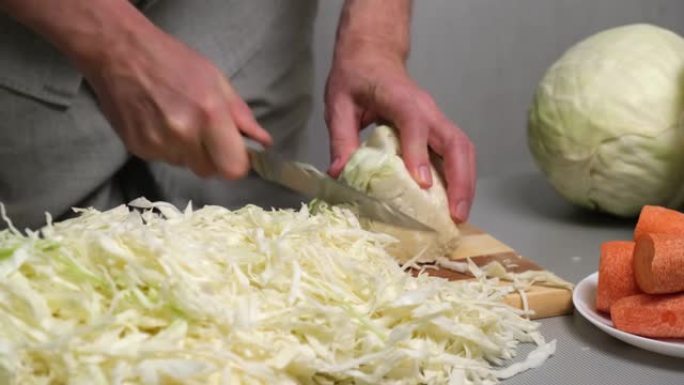 4K。男厨师用刀将新鲜的白菜切成薄片。酸菜的准备
