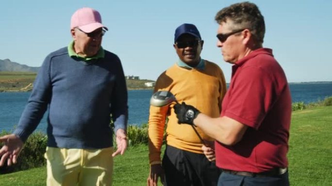 退休的男高尔夫球手准备在阳光明媚的湖边高尔夫球场开球