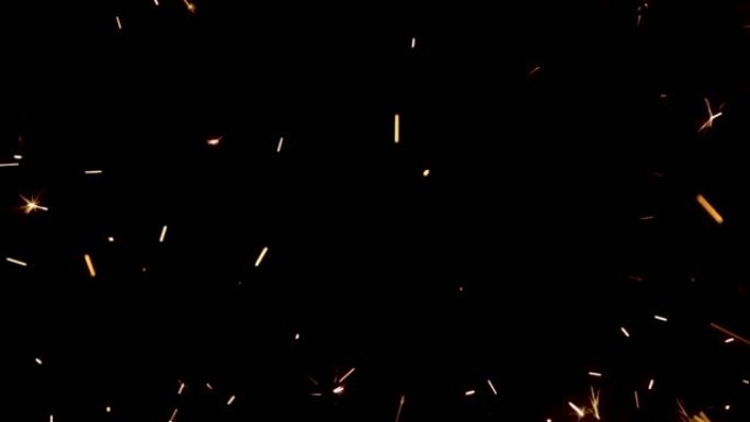 黑色背景上闪闪发光的孟加拉大火飞溅。在黑暗中闪耀着光芒的颗粒。闪闪发光的孟加拉烟花，带有金色的火花。