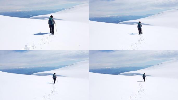 成功的登山者正在雪地中行走冬季天气中的高海拔山峰