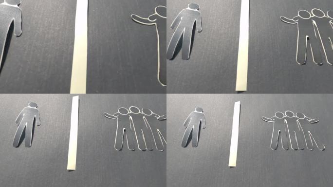 一张纸显示了一个与团体隔离的纸人。感到被冷落和孤独。社会隔离和拒绝概念。