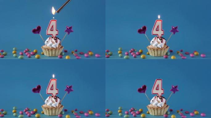 祝4岁的孩子生日快乐，带蜡烛的生日蛋糕和蓝色背景上的生日装饰品。点燃并熄灭纸杯蛋糕上的节日蜡烛。