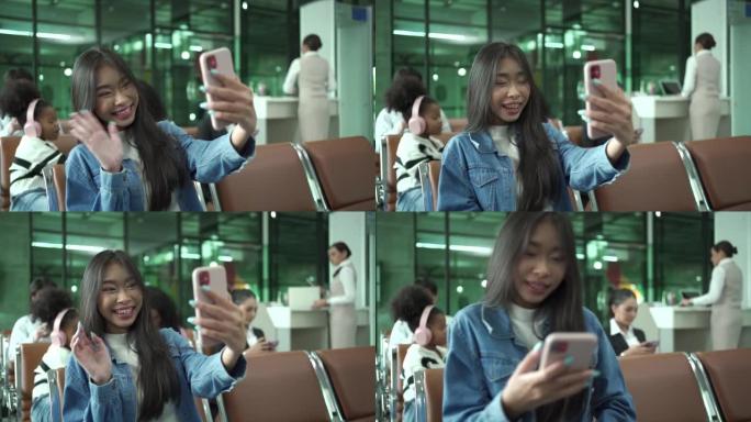 快乐的亚洲乘客在航班起飞前打视频电话。