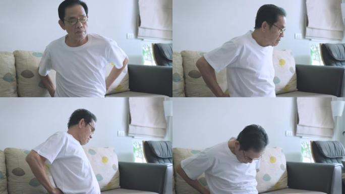 亚洲老人带一只手到腰上缓解背部疼痛，老人背痛在客厅家沙发上靠窗