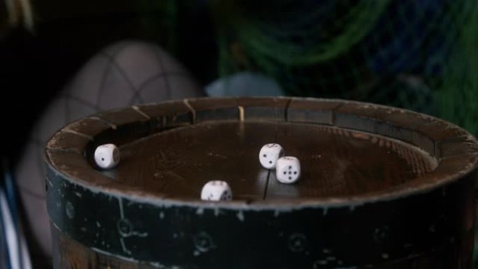 海盗喜欢掷骰子游戏，在海盗船船舱的图案旧木桶顶部投掷标记的立方体骰子