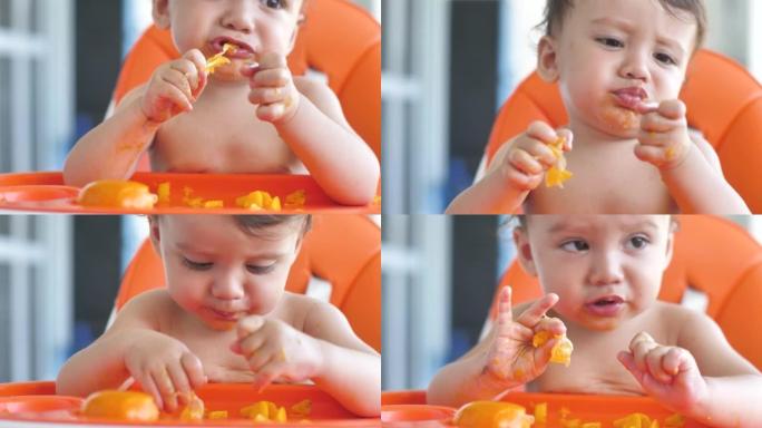 一个可爱的婴儿的特写镜头，坐在喂奶的椅子上，自己高兴地吃水果。从出生的儿童中摄取大量维生素的素食营养