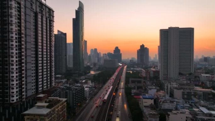 空中无人机在曼谷的超披亚河上的高速公路和地铁天空列车上的交通车灯的日出场景