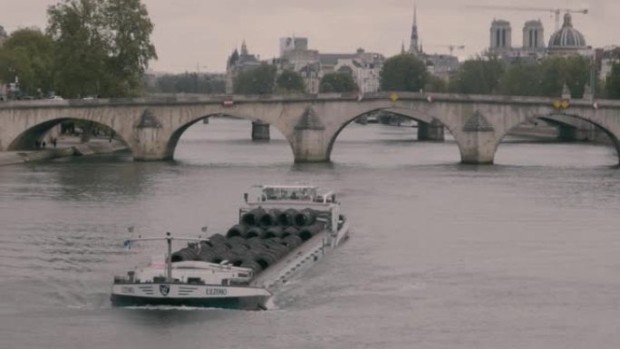 一艘装有轮胎的船漂浮在法国巴黎市的塞纳河上。哥特式建筑背景下的海船景观。