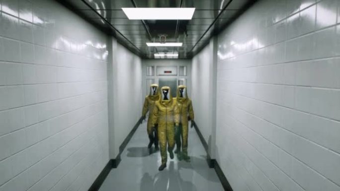 穿着化学防护服的病毒学家沿着医院大楼的走廊走。穿着特殊防护服的医生。该动画非常适合世界末日或医学背景