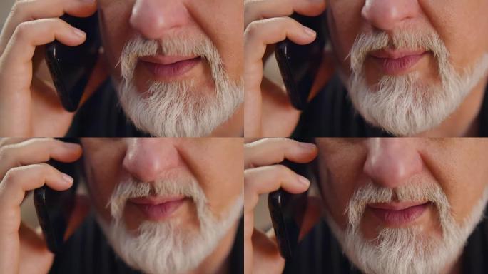 大胡子的高级男子在智能手机上聊天的特写