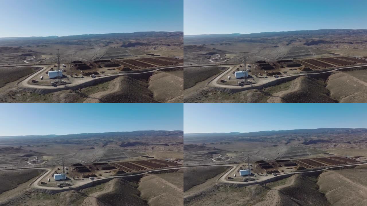 在冬天的晴天，空中射击从科罗拉多州沙漠中的可持续堆肥设施旁边的5g电信塔拉开，背景是科罗拉多州国家纪