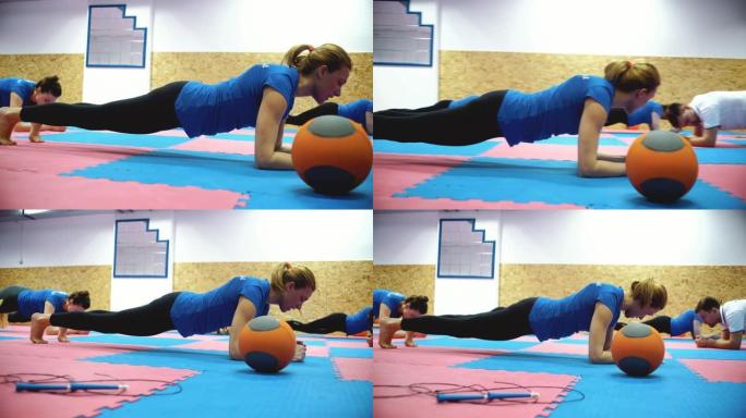 一群人在健身房做背部脊柱的木板运动