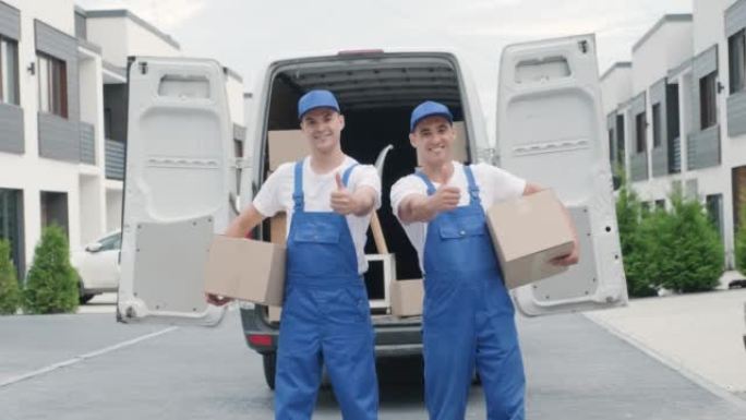 搬迁公司的两名年轻工人将箱子运送到客户的家中