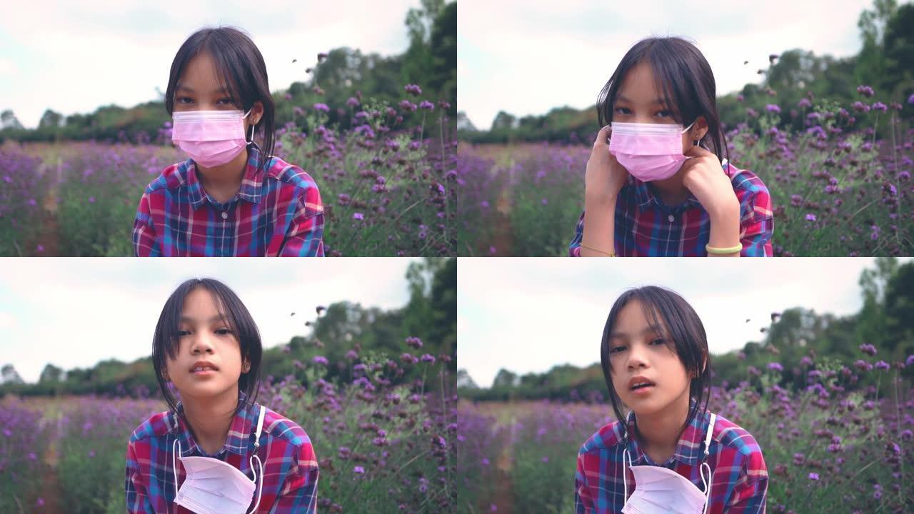 亚洲小女孩在户外花田里疲惫的一天后脱下面具，表情不开心。