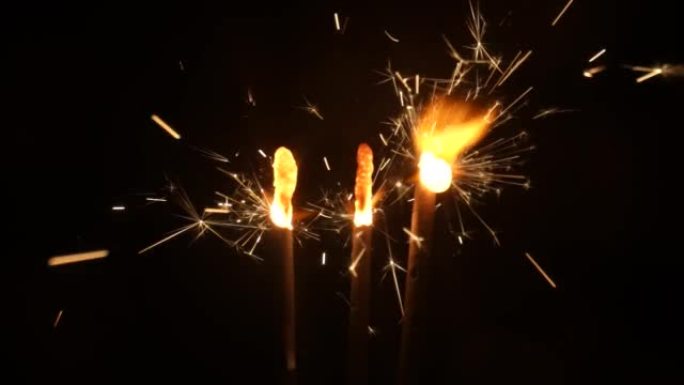 黑色工作室背景上的火花点火和燃烧。闪闪发光的孟加拉烟花，在黑暗中闪烁着金色的火花。概念假期，新年，派