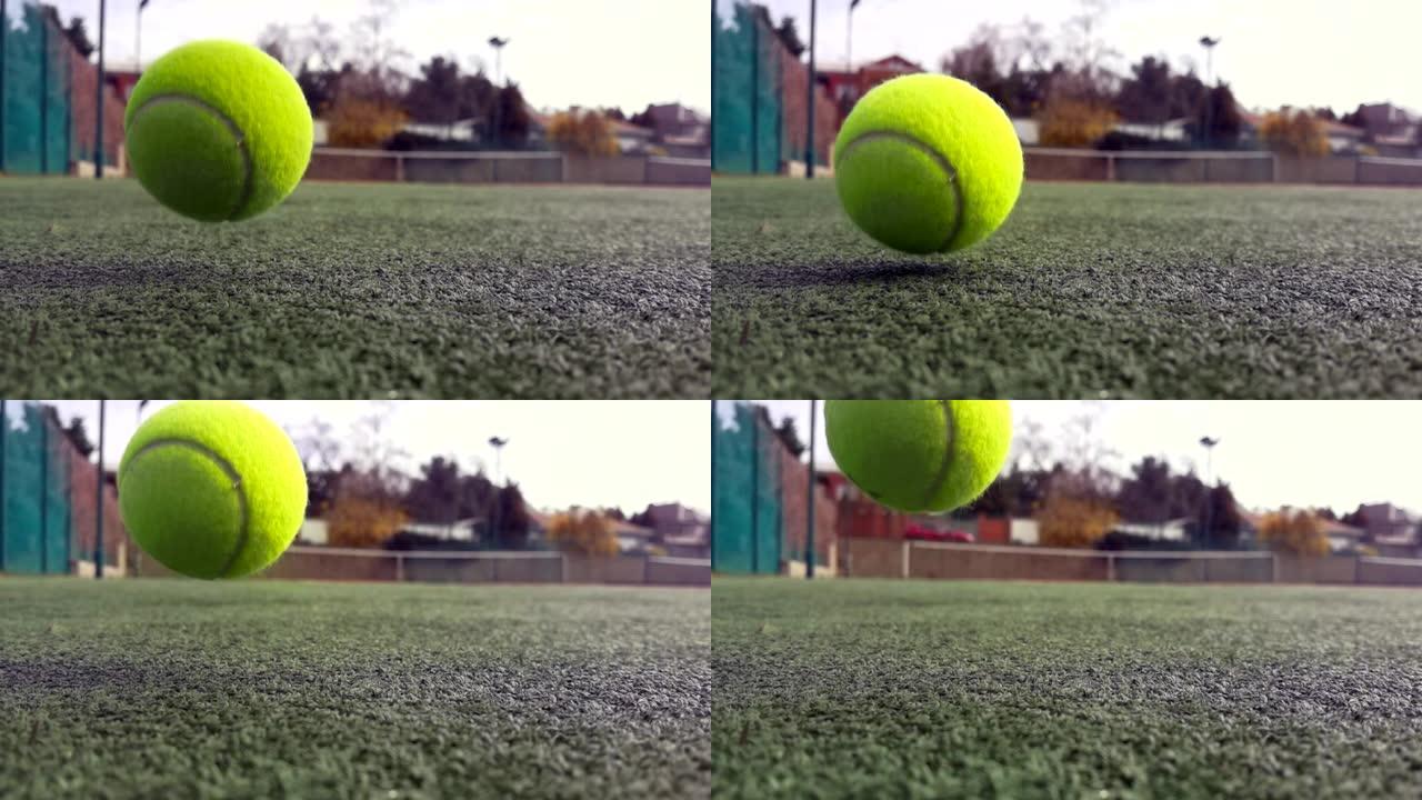 黄色网球在超级慢动作1000 fps在白线旁边的粘土绿色球场上，复制空间，软焦点和背景网。运动、娱乐