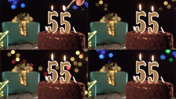 55岁生日，桌子上的甜蛋糕上有55号生日蜡烛。打火机上的火，吹灭节日蜡烛。