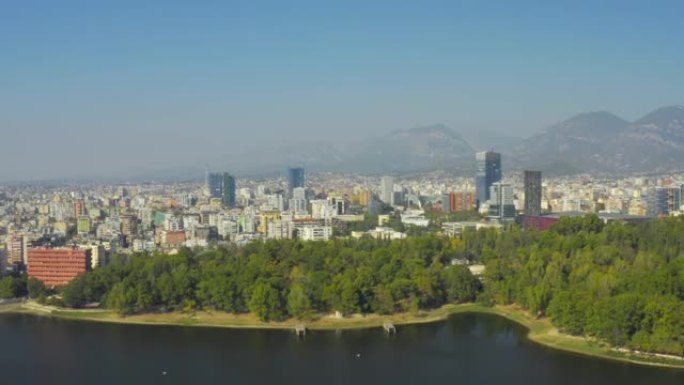 阿尔巴尼亚地拉那天际线的无人机视图。人工湖上的公园，地拉那大公园，山脉，摩天大楼，城市，空中，市中心