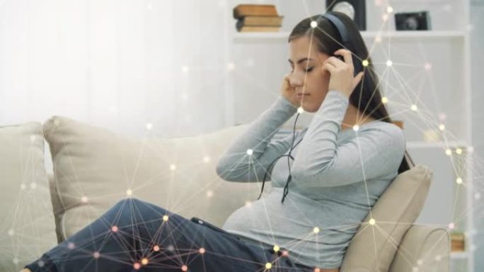 4k孕妇用神经丛粒子听音乐的慢动作视频。