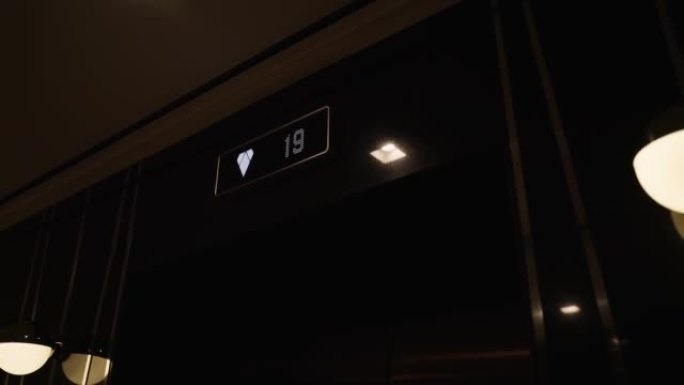 Led标志，带楼层数，向下箭头，位于建筑物电梯旁边。
