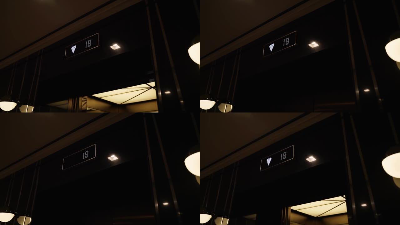 Led标志，带楼层数，向下箭头，位于建筑物电梯旁边。