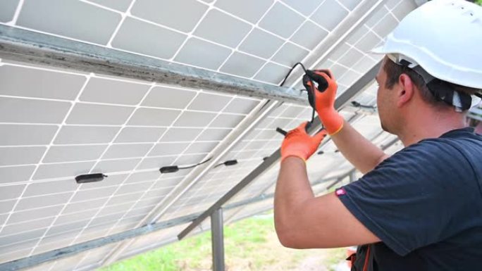 安装光伏太阳能电池板的男性太阳能技术员。