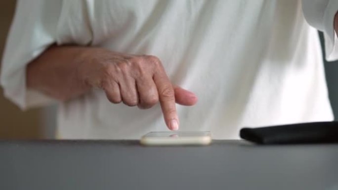 一位年长的妇女在手机屏幕上用手指打字