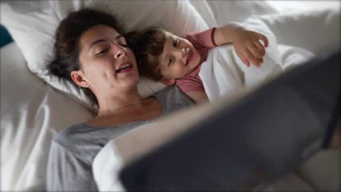 父母在床上给孩子读睡前故事