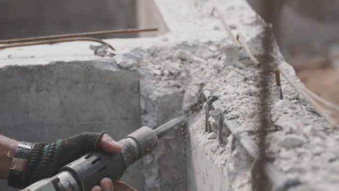 建筑工人正在用钻头钻砖石