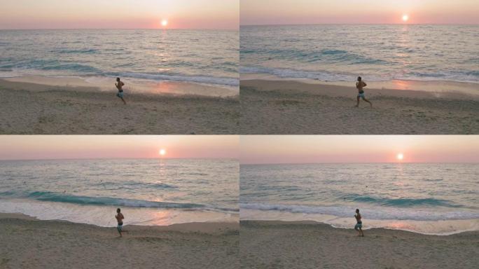 空中低空侧跟随在日落金色阳光下沿着海滩奔跑的人的景色。平静地看到海浪向海岸滚动