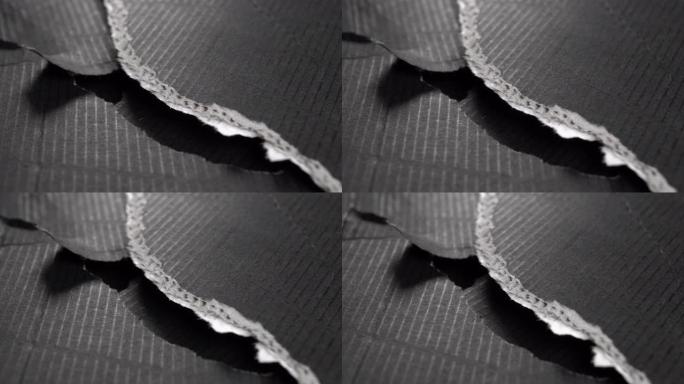 撕裂的黑色纸边。波纹撕裂纸板层。垃圾表面