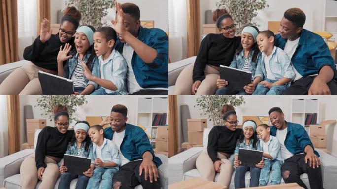 一家人在沙发上共度时光，父母和他们的两个孩子在平板电脑上与祖父母视频聊天，对着镜头挥手打招呼，交谈