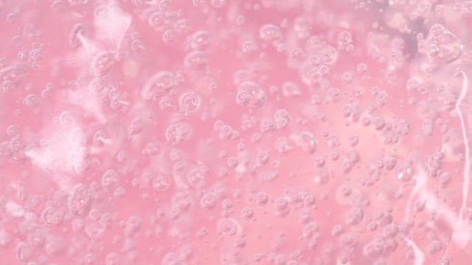 宏观粉色透明化妆品血清凝胶，乳霜，有气泡的液体质地