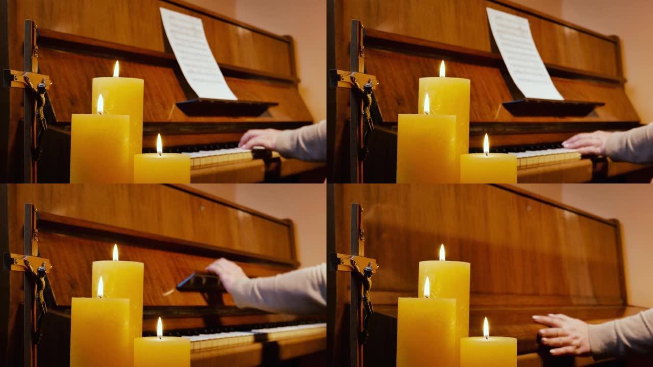用燃烧的蜡烛和耶稣受难像在立式钢琴上演奏宗教基督教音乐