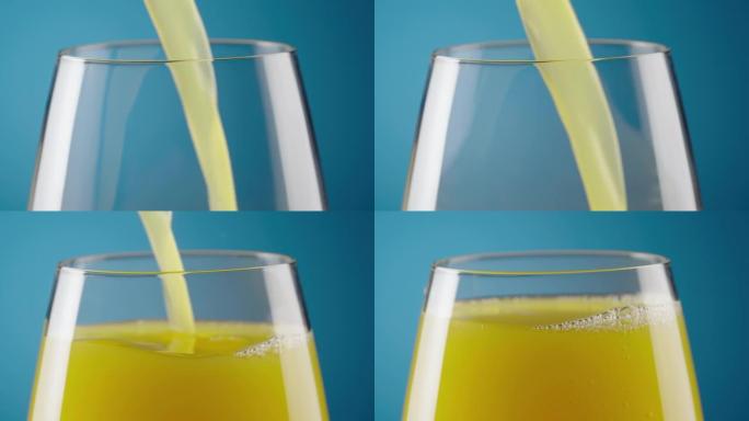 在蓝色背景上倒鲜榨天然橙汁的玻璃微距拍摄。玻璃杯中充满异国情调的柑橘花蜜或柠檬水。饮食健康的热带早餐