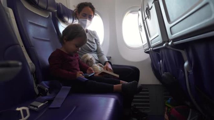 快乐的蹒跚学步的孩子和妈妈一起坐飞机