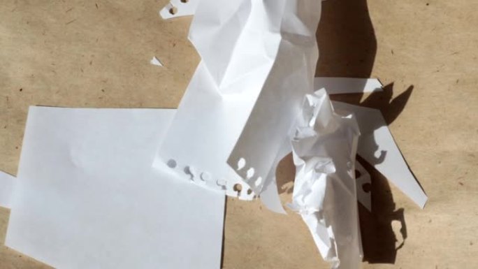 4k视频，棕色牛皮纸背景上皱巴巴的白色床单飞离风的微距摄影