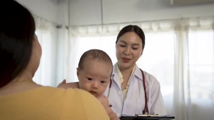 4k，亚洲妇女抱着一个刚出生的婴儿2个月大的亚洲生病的女医生在医院监督和检查身体