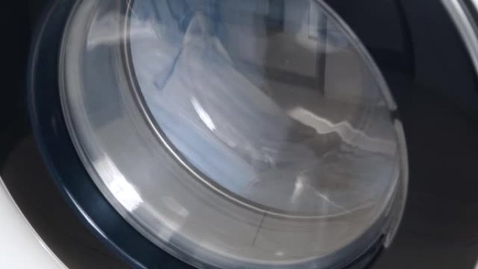 洗衣机洗脏医用口罩。旋转滚筒洗衣机的特写视频