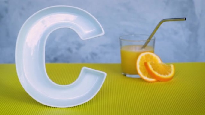 食品概念中的维生素c。用陶瓷字母C和鲜榨橙汁组成，背景为灰色和黄色。抗坏血酸对免疫系统功能很重要。