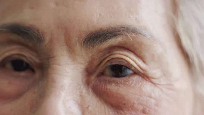 亚洲高级女性 (80岁) 的特写脸和眼睛，白发，希望用眼睛接触相机，露出满脸的皱纹，为她享受退休生活