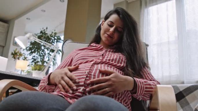 成为母亲。孕妇坐在摇椅上摇摆，放松。