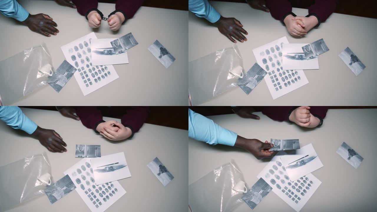 俯视图的非裔美国侦探显示证据照片的罪犯在手铐