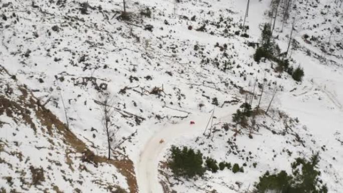 两个剪影使用雪橇在雪山上行驶，无人机射击