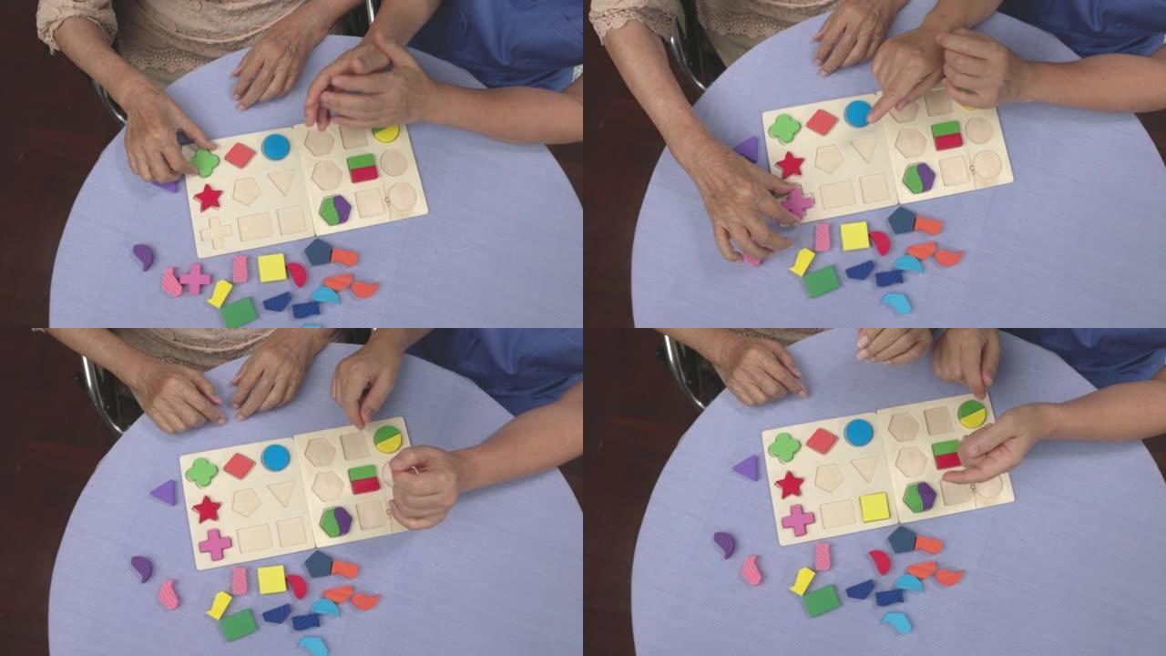 护理人员和老年妇女玩木制拼图游戏预防痴呆症。