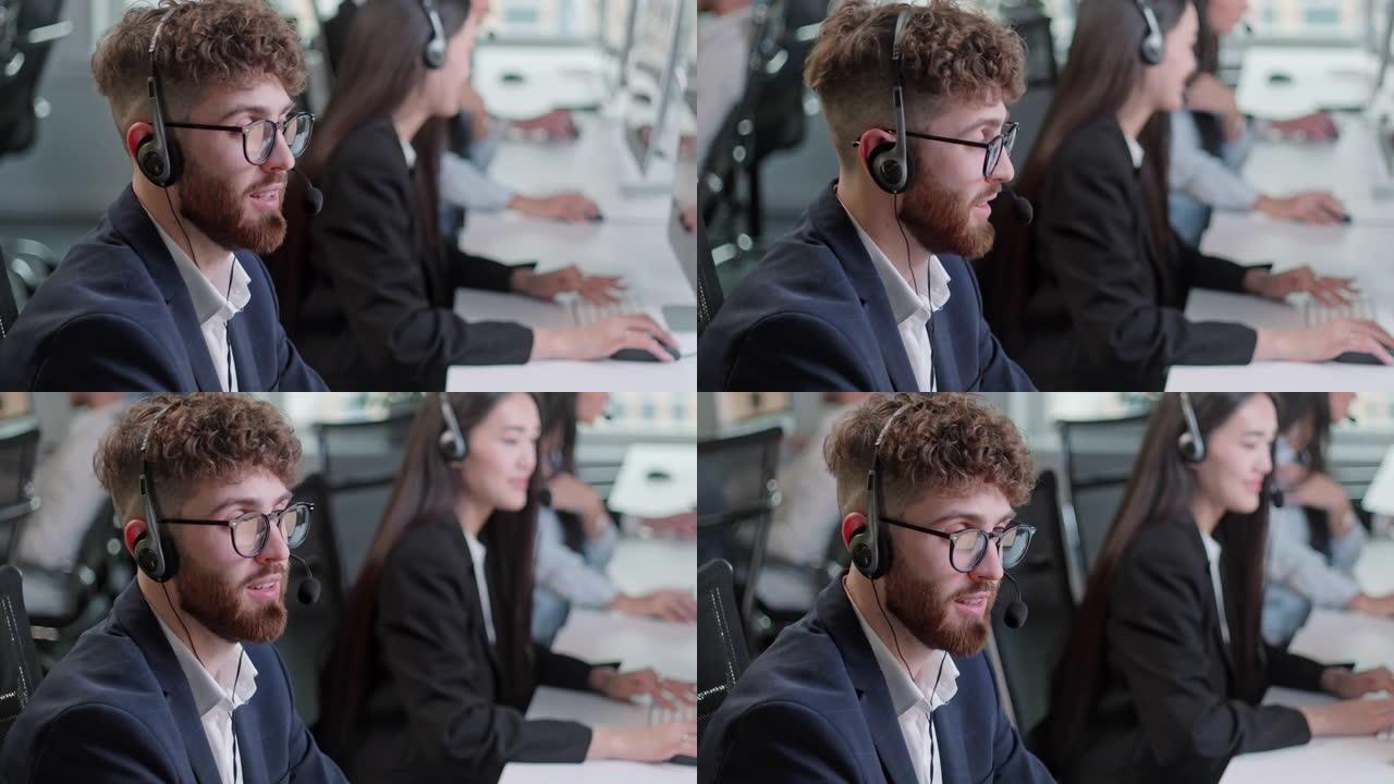 在呼叫中心的计算机上工作时，技术客户支持专家的特写肖像人物在耳机上交谈。多元化的工人团体谈论销售热线