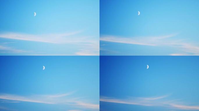 黄昏时的半月形。月亮在傍晚穿越蓝天