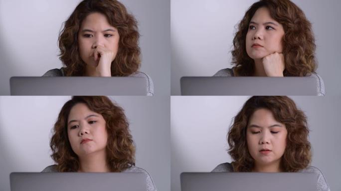 感到疲倦和压力。年轻的亚洲妇女坐在办公室里用笔记本电脑工作时，思想深处疲惫不堪。
